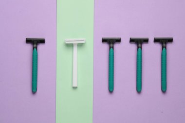 Pastel arka planda tek kullanımlık plastik jiletler, güzellik konsepti. Üst Manzara. Yaratıcı yerleşim