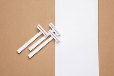 Beyaz arka planda beyaz plastik jiletler. Minimalizm güzelliği hala hayat. Boşluğu kopyala