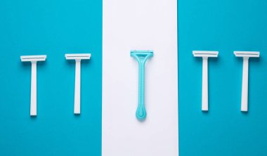 Mavi beyaz arka planda tek kullanımlık plastik jiletler, minimalizm güzelliği hala soluk. Üst Manzara. Yaratıcı yerleşim