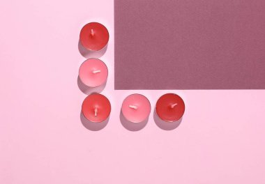 Pembe arka planda Aroma çayı mumları. Üst Manzara. Yaratıcı yerleşim