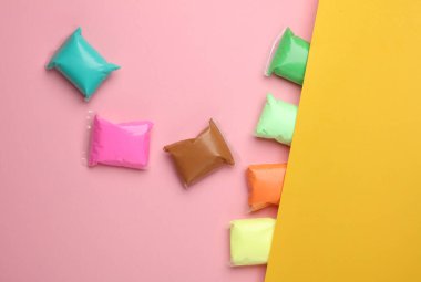 Renkli hava plastiklerinin seti, pembe sarı arka plan. Çocukların yaratıcılığı. Üst görünüm