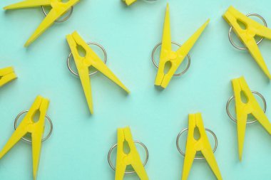 Mavi arkaplanda sarı plastik mandallar