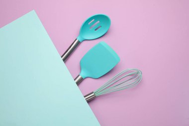 Pastel arka planda silikon mutfak aletleri. Üst görünüm