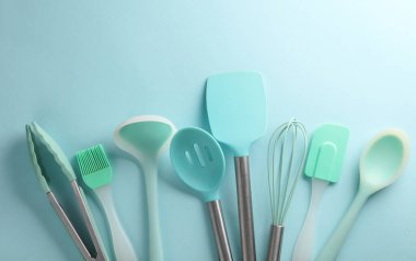 Mavi arka planda silikon mutfak aletleri. Üst görünüm
