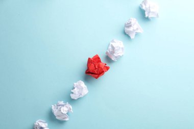 Kırışmış beyaz ve kırmızı toplar mavi arka planda. Liderlik, eşsizlik, iş konsepti