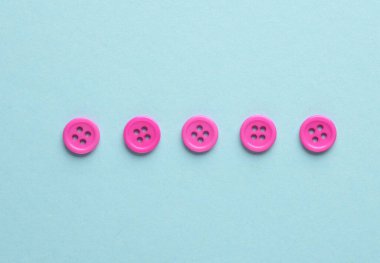 Mavi arkaplanda plastik pembe düğmeler
