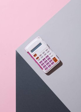 Gri küpün köşesindeki hesap makinesi. Optik geometrik yanılsama. İş konsepti. Yaratıcı düzen. Minimalizm