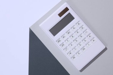 Gri küpün köşesindeki hesap makinesi. Optik geometrik yanılsama. İş konsepti. Yaratıcı düzen. Minimalizm