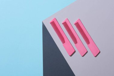 Gri küpün köşesindeki pembe taraklar. Optik geometrik yanılsama. Yaratıcı düzen. Güzellik konsepti. Minimalizm