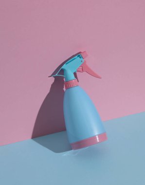 Mavi-pembe arka planda sprey şişesi. Minimalizm kompozisyonu. Yaratıcı yerleşim