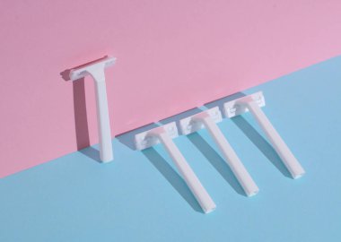 Mavi-pembe arka planda beyaz jiletler. Güzellik konsepti. Yaratıcı düzen, minimalizm