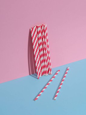 Mavi-pembe pastel arka planda kokteyl pipetleri. Yaratıcı yerleşim