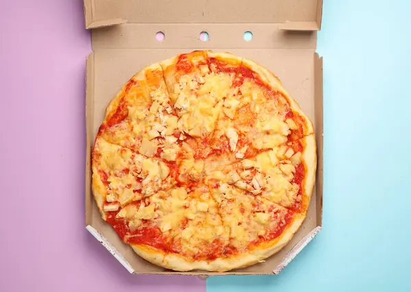 Pizza in box on a blue-pink background. Top view