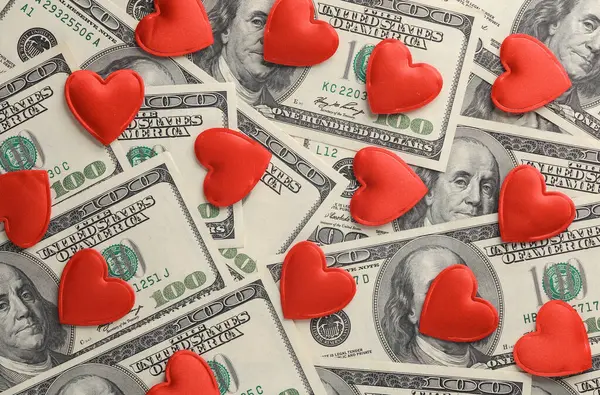 Red hearts on hundred dollar bills
