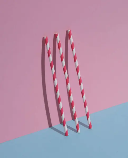 Cocktail straws on a blue-pink pastel background. Creative layout
