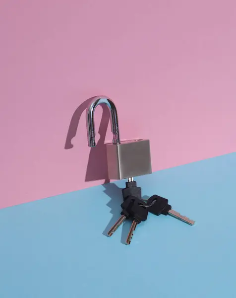Metal open lock with keys on a blue-pink background. Minimalism composition. Creative layout