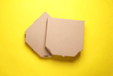 Sarı arka planda iki tane boş karton pizza kutusu. Tasarım şablonu. Üst görünüm