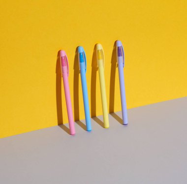 Renkli arka planda plastik renkli kalemler. İş, eğitim kavramı. Yaratıcı düzen, minimalizm. Modern sanat