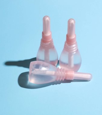 Mavi arka planda üç vajinal lavman. Kadın Sağlığı