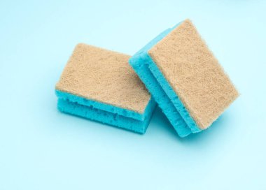 Mavi arka planda iki temizlik süngeri