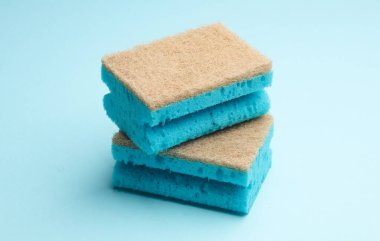 Mavi arka planda iki temizlik süngeri