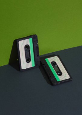 Geçmişe dönük 80 'lerin ses kasetleri yeşil arka planda ve gölgeli. Yaratıcı düzen, minimalizm, müzik aşığı