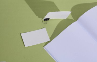 Boş defter ve kartvizitler yeşil arkaplanda
