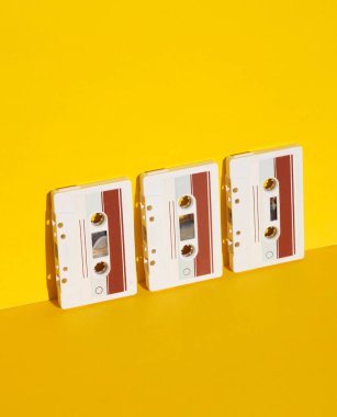 Retro 80s audio cassettes on yellow background with shadow. Creative layout, minimalism, music lover clipart