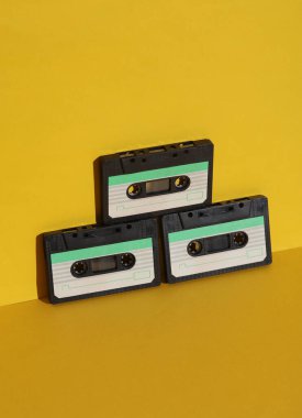 Sarı arka planda gölgeli Retro 80 ses kasetleri. Yaratıcı düzen, minimalizm, müzik aşığı
