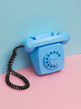 Pembe mavi arka planda gölgeli mavi Rotary döner telefon. Yaratıcı yerleşim