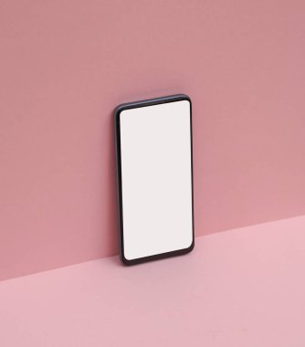 Pembe arka planda akıllı telefon. Yaratıcı yerleşim.