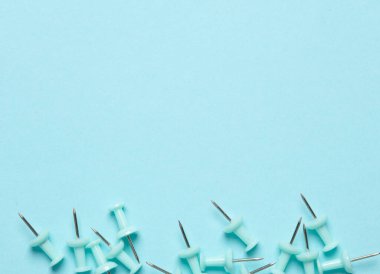 Mavi arka planda kırtasiye iğneleri. Boşluğu kopyala