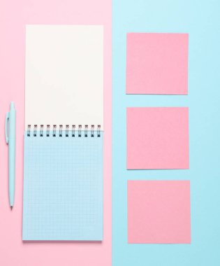 Not defterinde notlar, mavi-pembe pastel arka planda bir kalem. Yaratıcı yerleşim