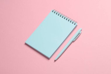 Pembe arka planı olan mavi bir defter. Minimalizm