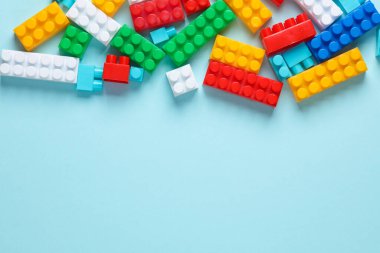 Mavi arka planda çocuk inşaatçısının renkli tuğlaları. Üst Manzara. Boşluğu kopyala