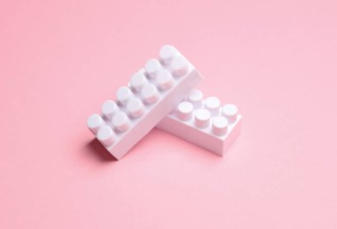 Pembe arka planda beyaz oyuncak blokları