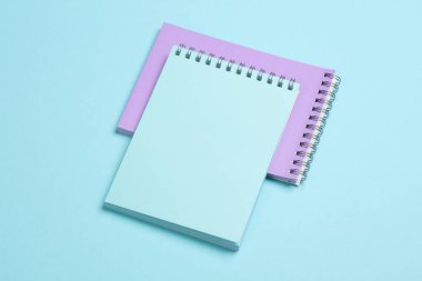 Mavi pastel arka plan üzerine iki defter. Minimalizm. Yaratıcı yerleşim