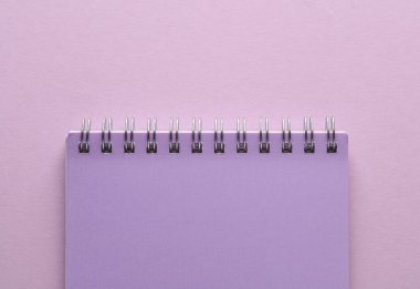 Eflatun pastel arka plan üzerine sarmal not defteri