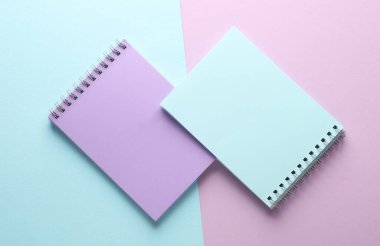Mavi mor renkli pastel arka plan üzerine iki defter. Minimalizm. Yaratıcı yerleşim