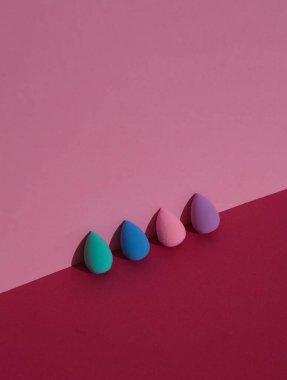 Pembe arka planda gölgeli makyaj blenderları. Güzellik konsepti. Yaratıcı düzen, minimalizm