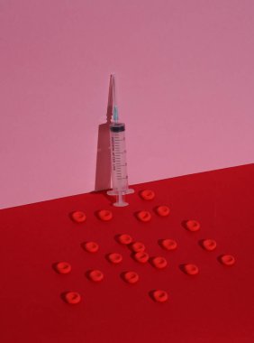 Renkli arka planda şırınga ve kırmızı kan hücreleri. Tıp konsepti. Yaratıcı yerleşim