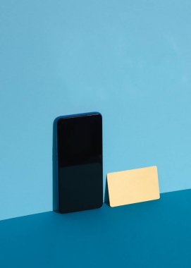 Mavi arka planda akıllı telefonlu altın kartvizit. Yaratıcı iş düzeni