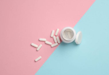 Mavi-pembe arka planda ilaç şişesi. Üst görünüm