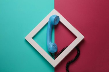 Pembe arka planda beyaz çerçeveli Retro telefon alıcısı. Yaratıcı düzen. Minimalizm