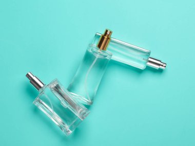 Mavi arka planda parfüm şişeleri. Yaratıcı güzellik düzeni. Minimalizm