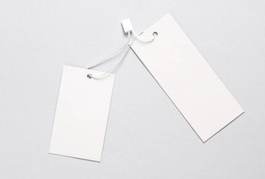 İplerdeki iki beyaz fiyat etiketinin modeli, gri arkaplan