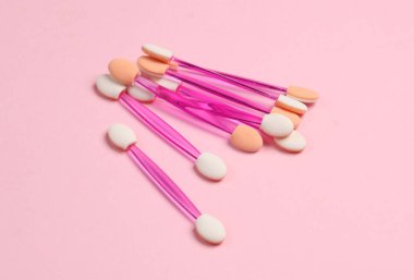 Pembe arka planda makyaj için aplikatörler.
