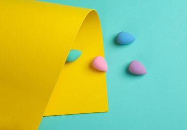 Mavi sarı arka planda makyaj pufları. Güzellik konsepti