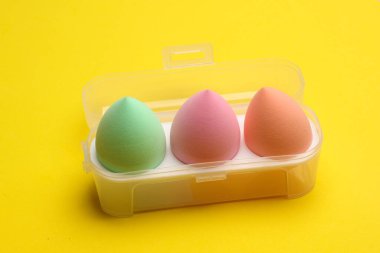 Makyaj pufları sarı arka planda. Güzellik konsepti