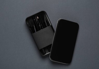 Arka planda siyah makyaj fırçaları ve metal kutular. Güzellik konsepti